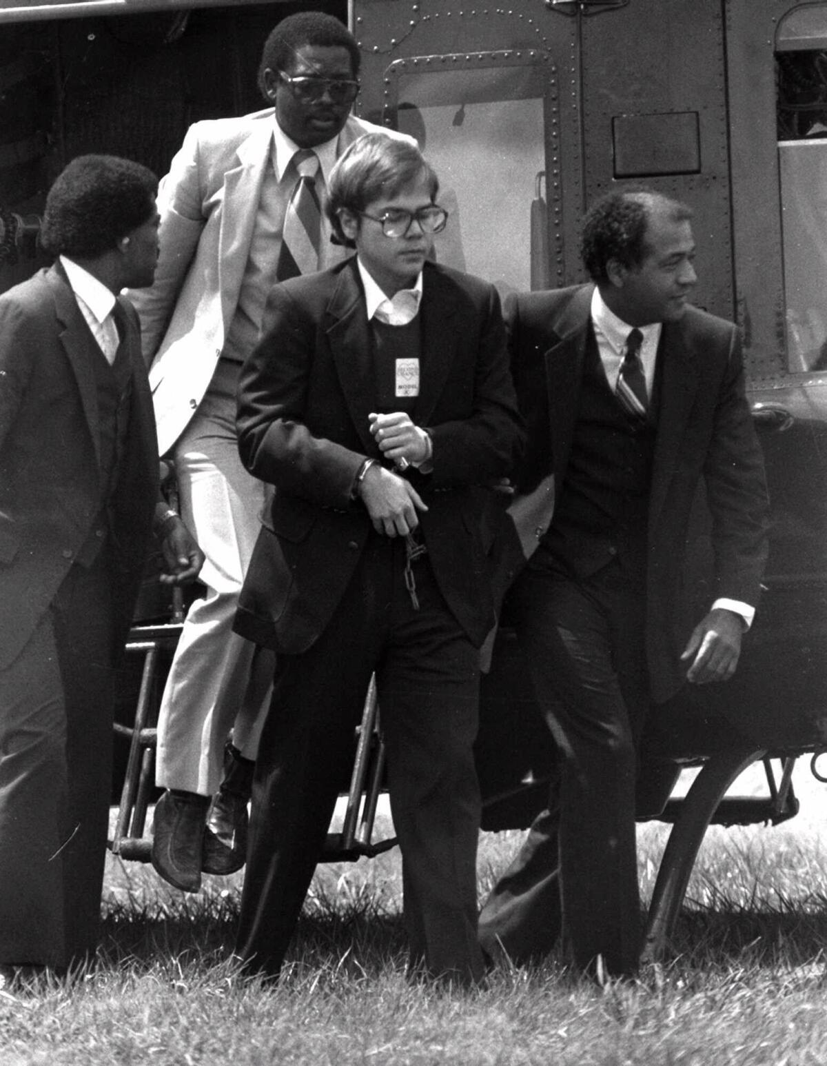 John W. Hinckley, Jr. is shown arriving in chains at Quantico Marine Base on Aug. 18, 1981.