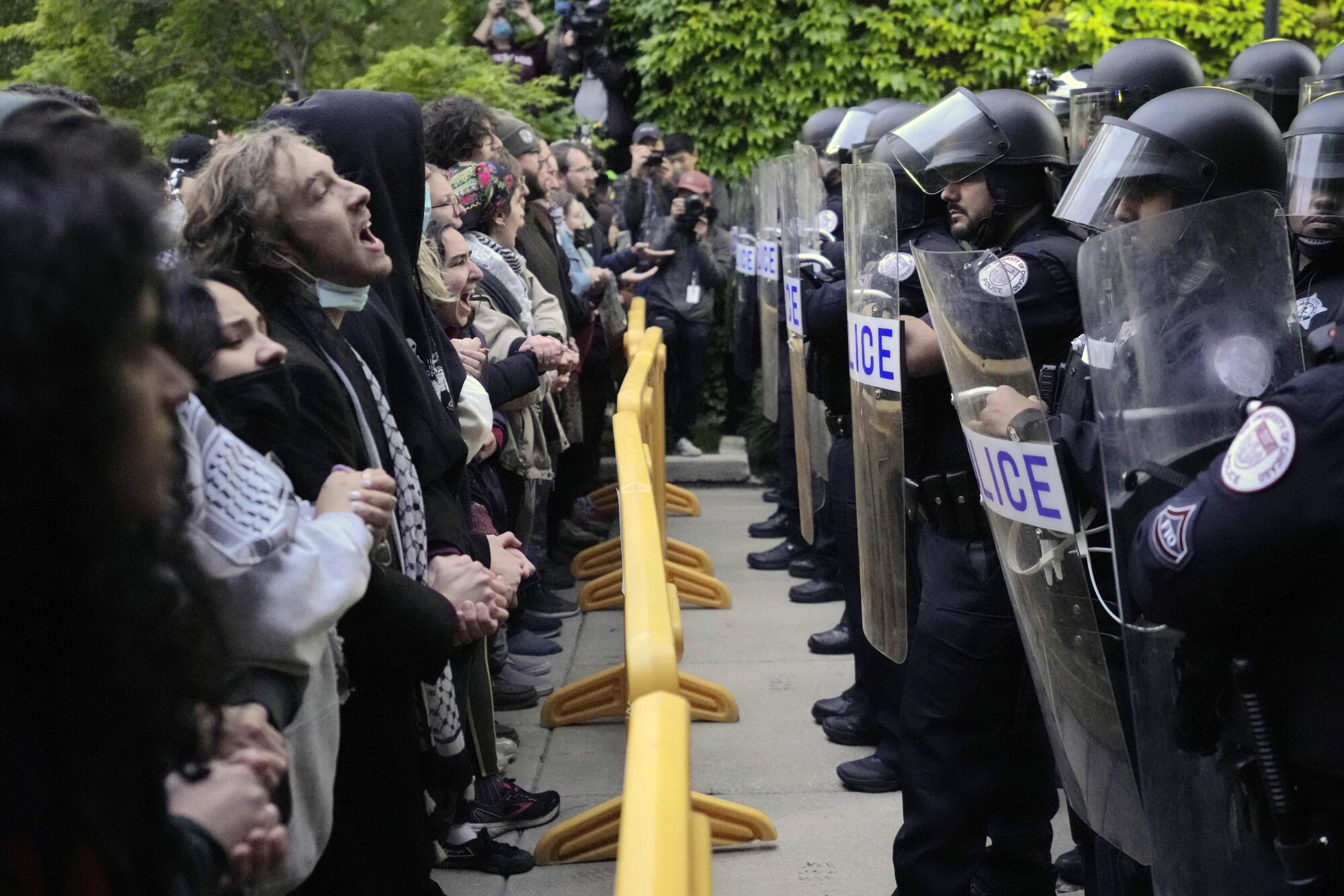 Pro-Palestinian protesters chant at University of Chicago police while being kept