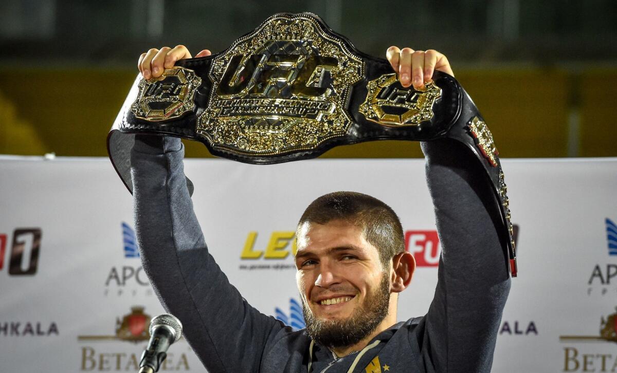 UFC lightweight champion Khabib Nurmagomedov of Russia raises his champions belt upon the arrival in Makhachkala on October 8, 2018. - Nurmagomedov defeated Conor McGregor of Ireland in their UFC lightweight championship bout by way of submission during the UFC 229 event inside T-Mobile Arena on October 6, 2018 in Las Vegas, Nevada.