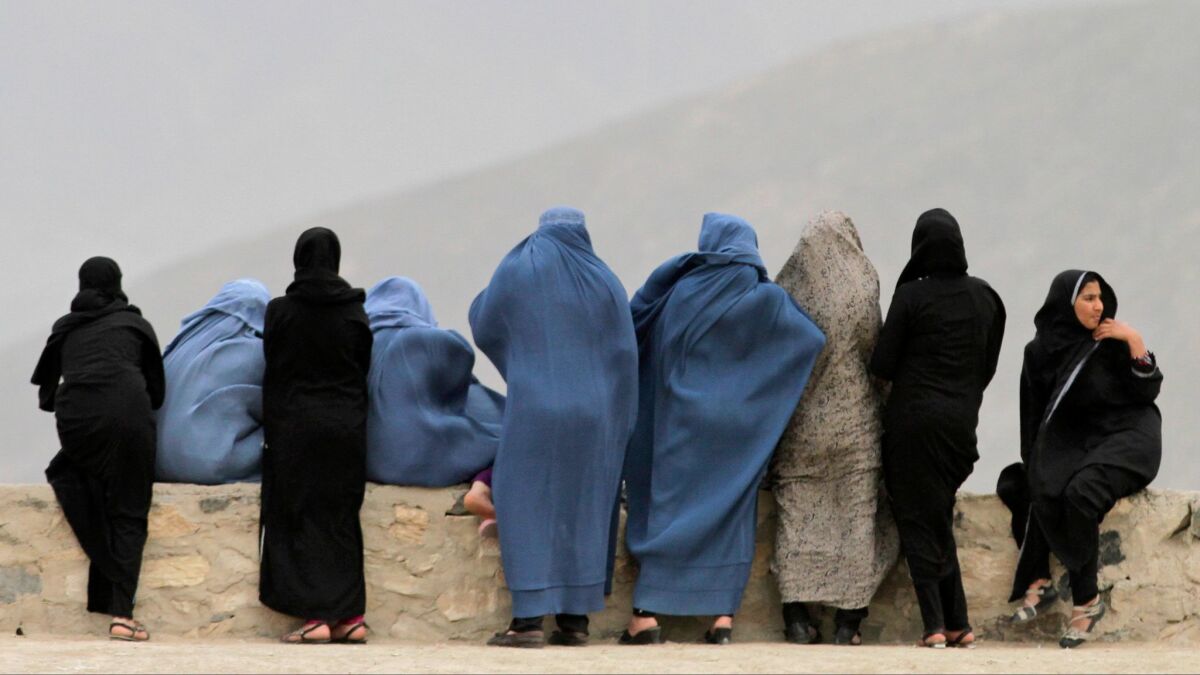 Afghani women look out over Kabul from a hill in 2013.