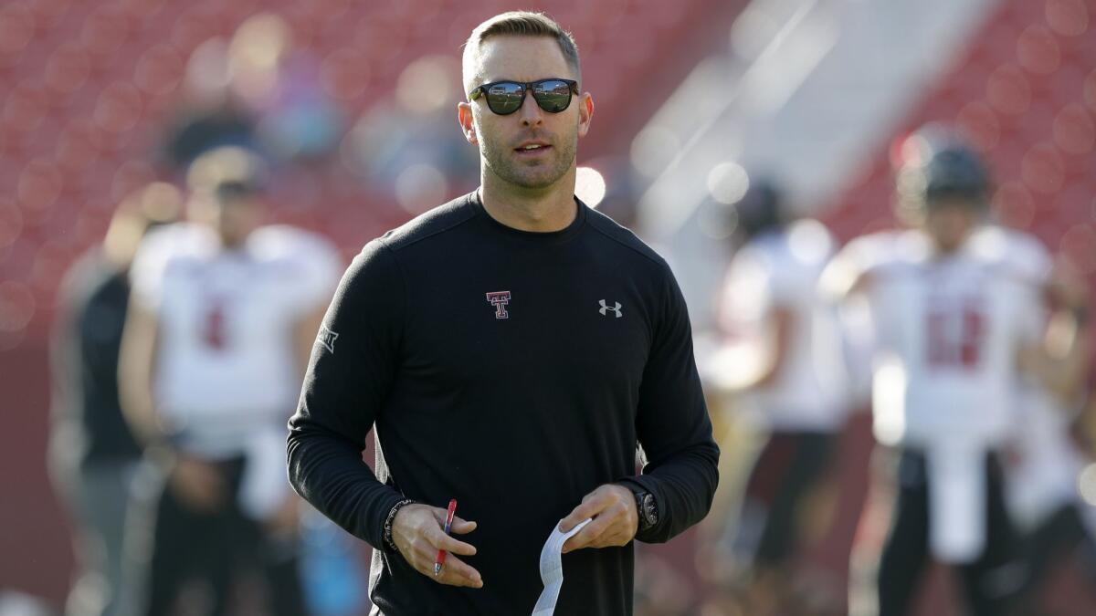 Kliff Kingsbury standing on the field before a game against Iowa State.