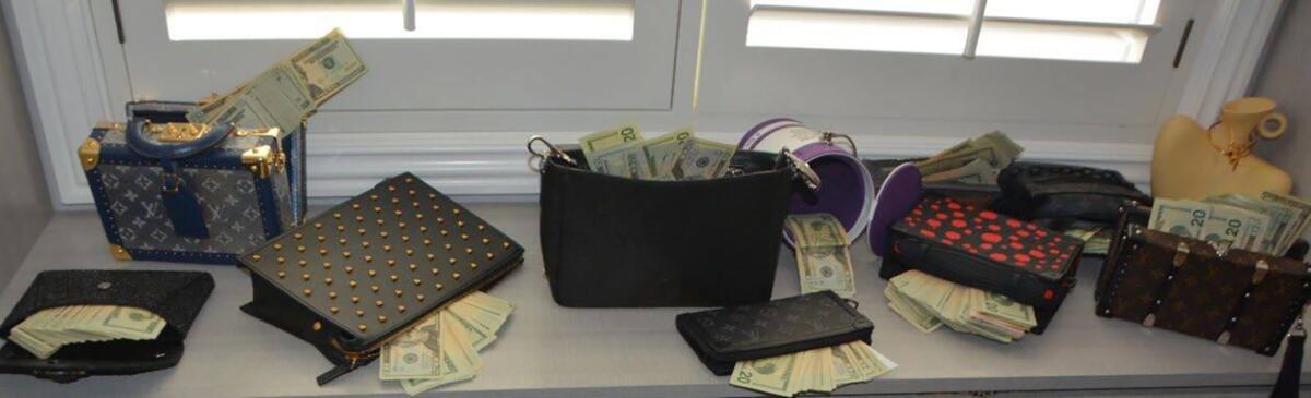 Handbags filled with cash lined up on a window seat