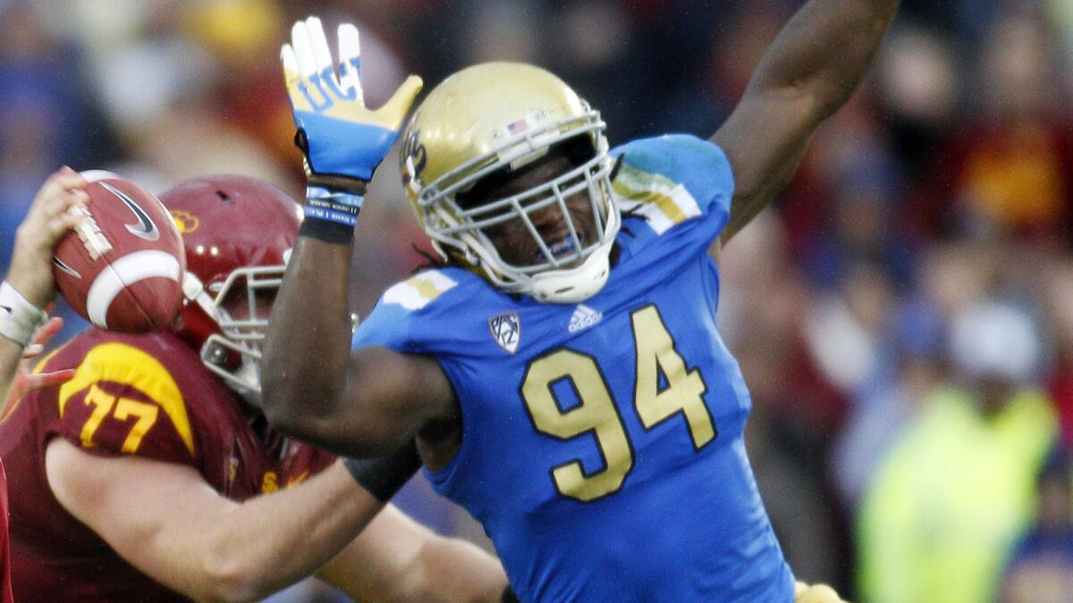 UCLA defensive end Owamagbe Odighizuwa pressures USC quarterback Matt Barkley during a game in November 2012. Odighizuwa is one of several top UCLA players who were recruited by former coach Rick Neuheisel.