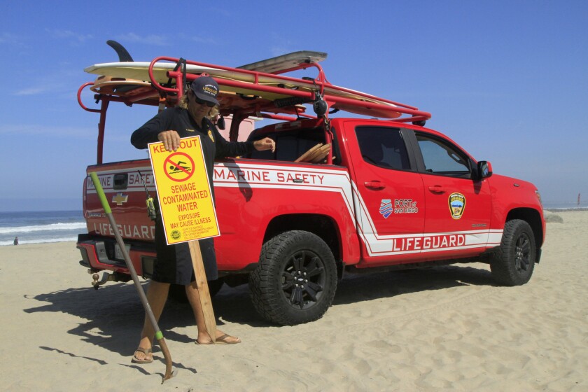 Adam Wraight, marine safety sergeant with Imperial Beach Lifeguards, posts signs warning people to stay out of the water