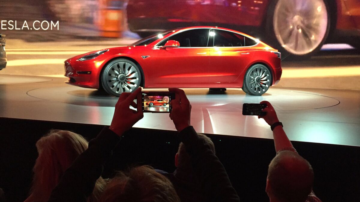 Tesla Motors unveils its Model 3 sedan at the company's design studio in Hawthorne on March 31.