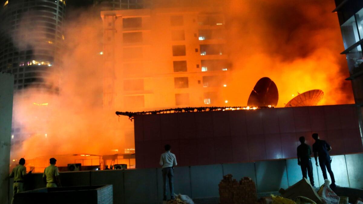 People watch as a huge fire engulfs a rooftop restaurant in Mumbai on Dec. 29.