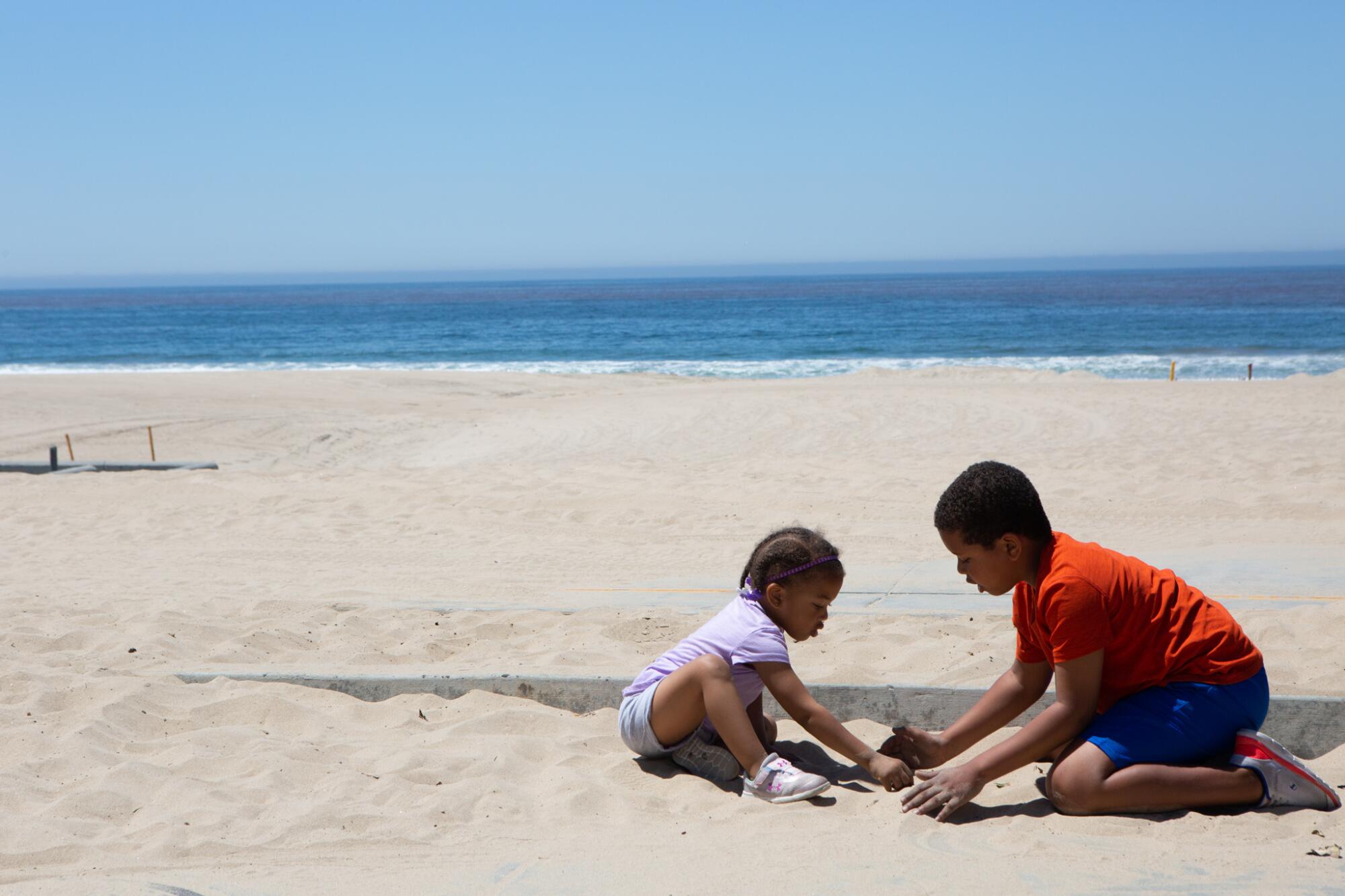 Kennedy Bobo, 2, and her brother Jackson Bobo, 6, played on a sidewalk near the Strand walking and bike path in Manhattan Beach.