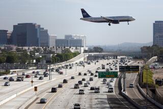 Schaben, Allen J. –– B581716186Z.1 SANTA ANA, CA – NOVEMBER, 23, 2011: A U.S. Airways airplane flies over the 405 freeway as it approaches it's landing at John Wayne Airport in Orange County as travelers make their way to their destinations in time to celebrate Thanksgiving. ( Allen J. Schaben / Los Angeles Times)