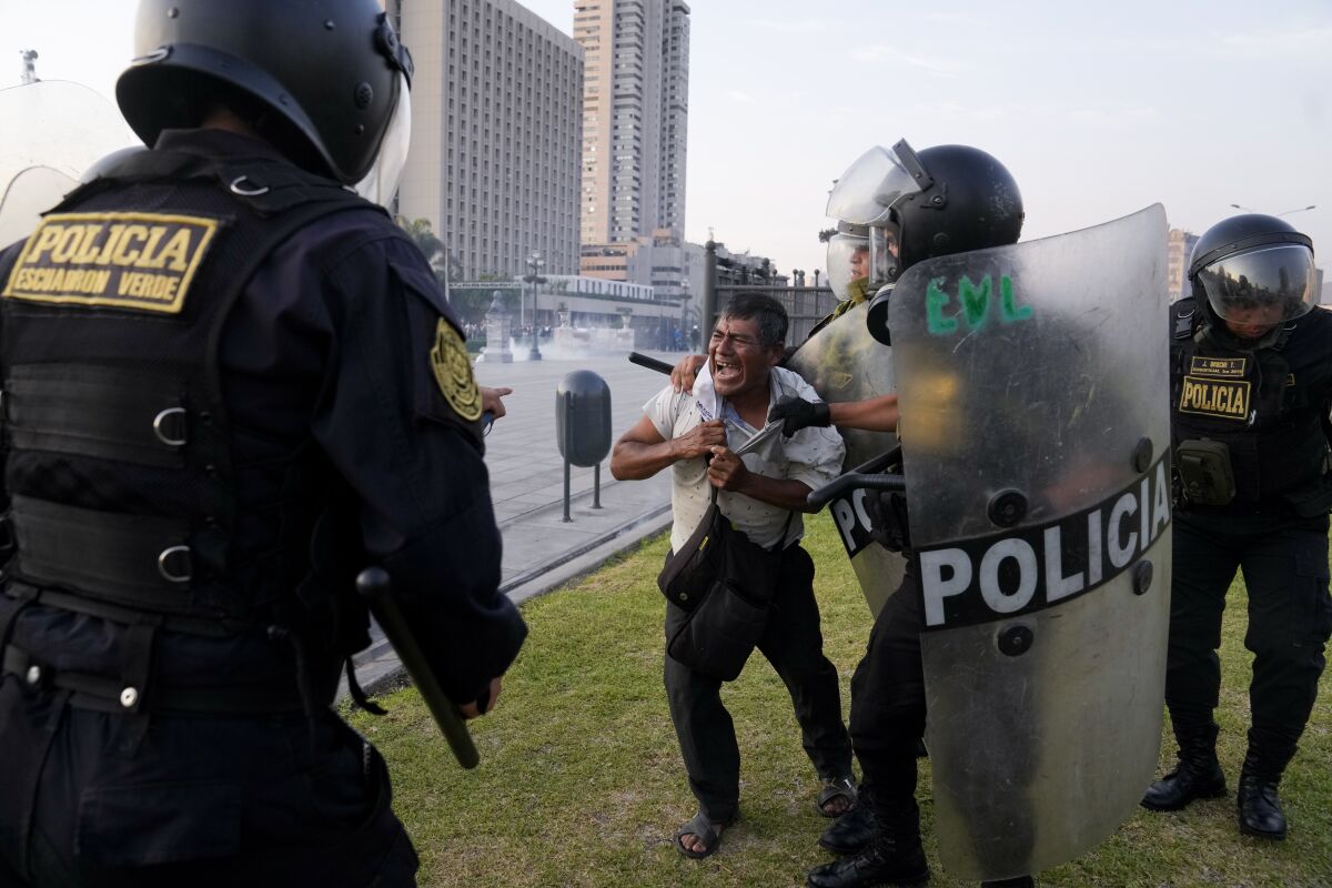 Un policía detiene a un manifestante de oposición al gobierno en Lima, Perú, 