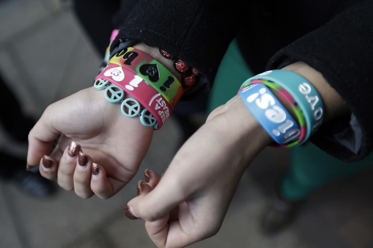 Easton Area School District students Brianna Hawk, 15, left, and Kayla Martinez, 14, display their bracelets for photographers outside the U.S. Courthouse in Philadelphia.