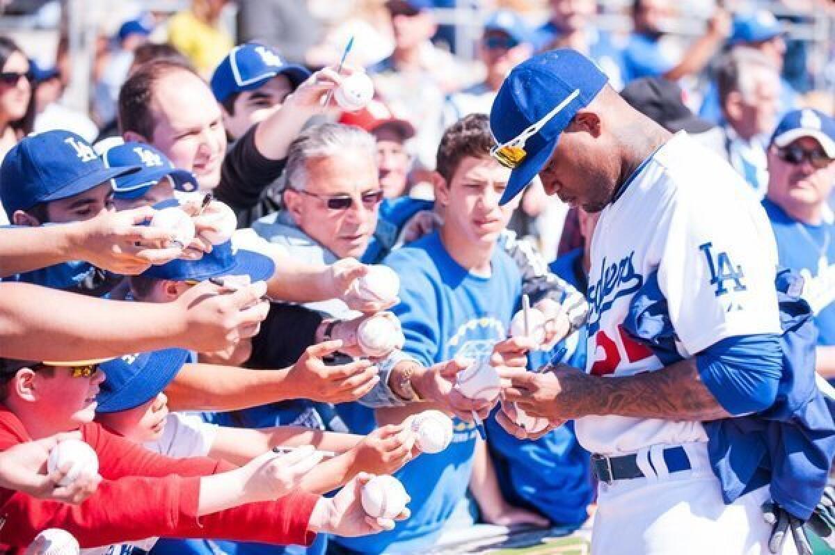 Carl Crawford signs autographs at spring training last month.