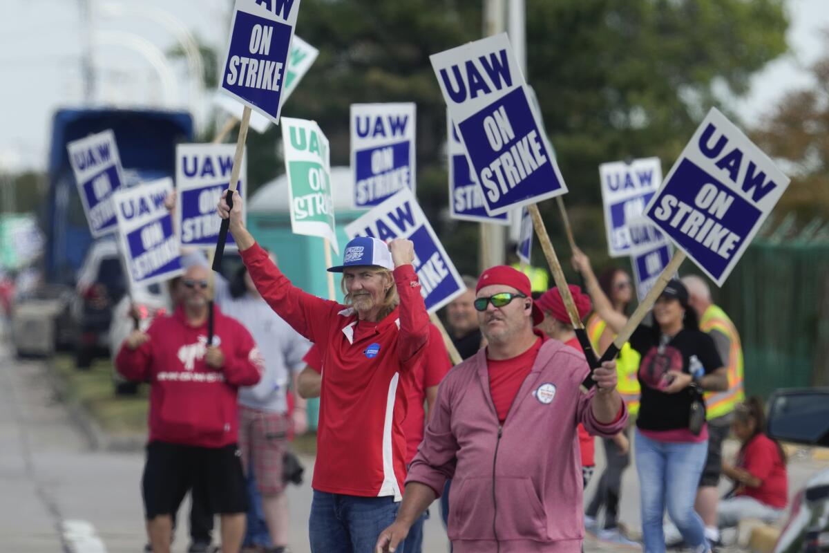 United Auto Workers members walk a picket line 