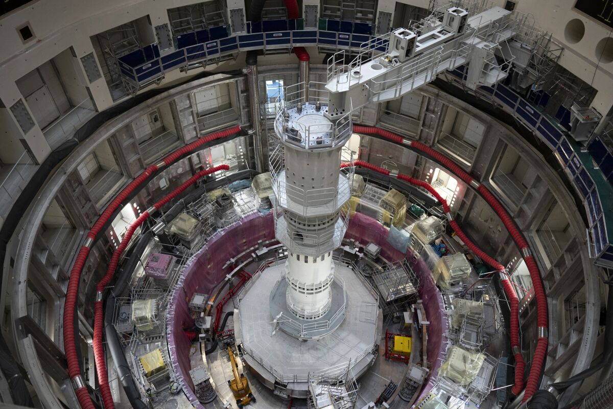 A circular, atrium several stories deep holds scientific equipment surrounding a central column