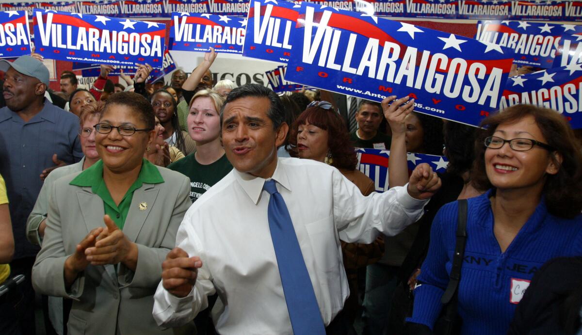 A man in shirt and tie with a crowd of people holding "Villaraigosa" campaign signs.