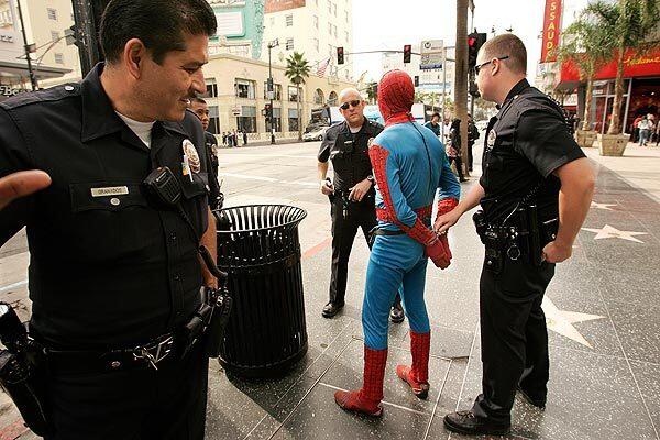 LAPD officers arrest a man in a Spider-Man outfit after he allegedly assaulted a man on the 6800 block of Hollywood Boulevard in Hollywood on Wednesday. The victim refused to press charges, but the Spider-Man character was still booked on outstanding misdemeanor charges.