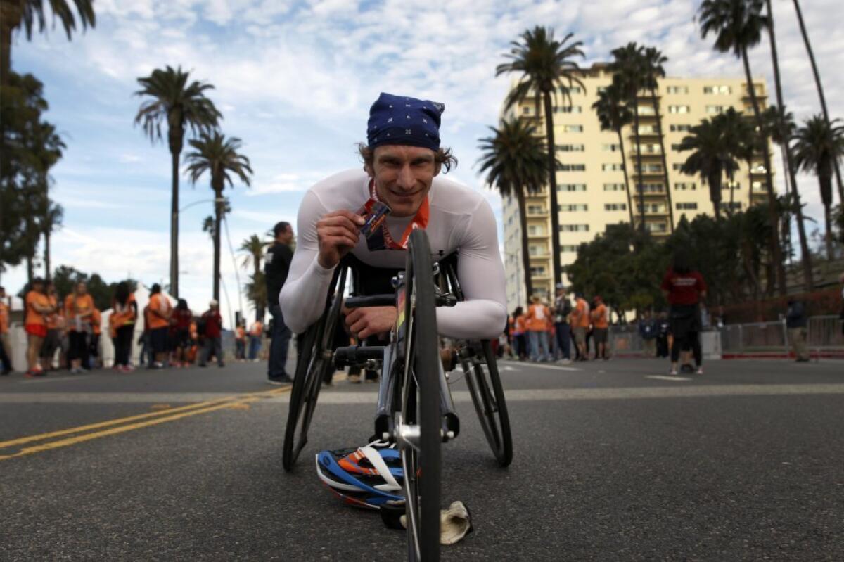 Joshua George of Champaign, Ill., holds his first-place medal after winning the wheelchair division of the Los Angeles Marathon.