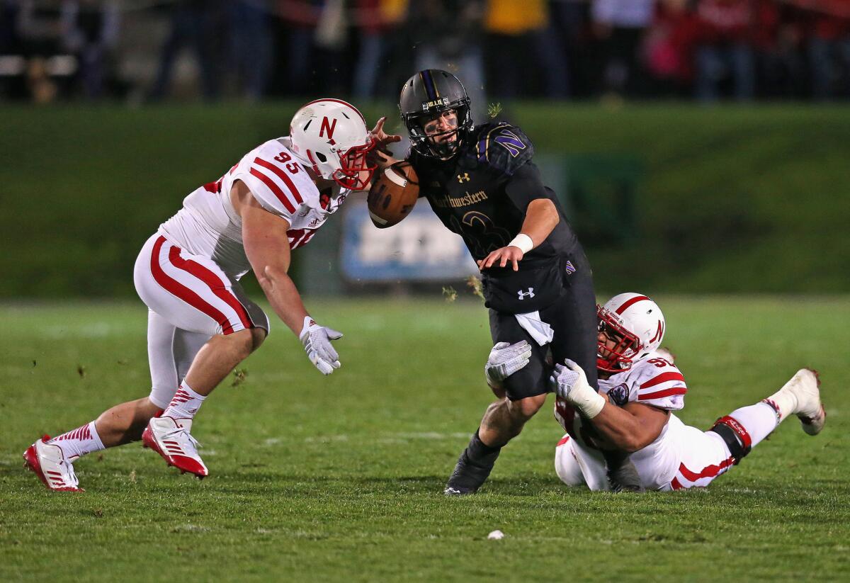 Nebraska defensive end Jack Gangwish, left, causes Northwestern quarterback Trevor Siemian, center, to fumble the ball during a game on Oct. 18.
