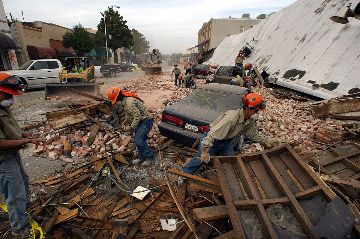 Rescue workers sift through debris in the wake of the 2003 Paso Robles earthquake. (Spencer Weiner / Los Angeles Times)