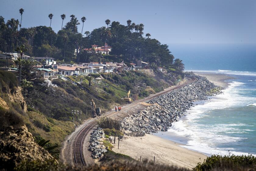 San Clemente, CA - September 21: Metrolink and Amtrak have been forced to suspend service between Orange and San Diego counties for several weeks as crews conduct emergency repairs caused by beach erosion in San Clemente Tuesday, Sept. 21, 2021. The Cyprus Shores gated community, shown at left, has been impacted by erosion and the La Casa Pacifica (previously owned by President Richard Nixon) located in the gated community of Cottons Point Estates/Cypress Shores upper-middle of photo, located at Cotton's Point. (Allen J. Schaben / Los Angeles Times)