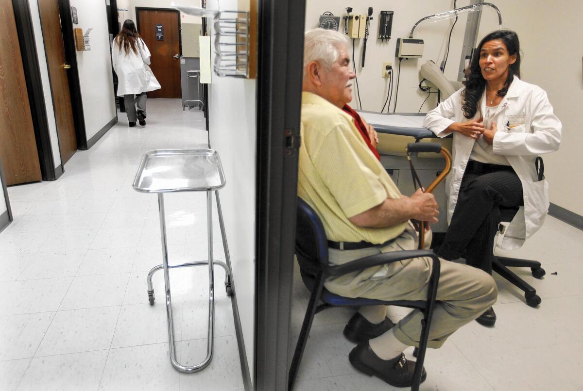 Dr. Gloria Sanchez of Harbor-UCLA Medical Center confers with patient Miguel Torres in the Harbor City hospital's family medicine clinic.