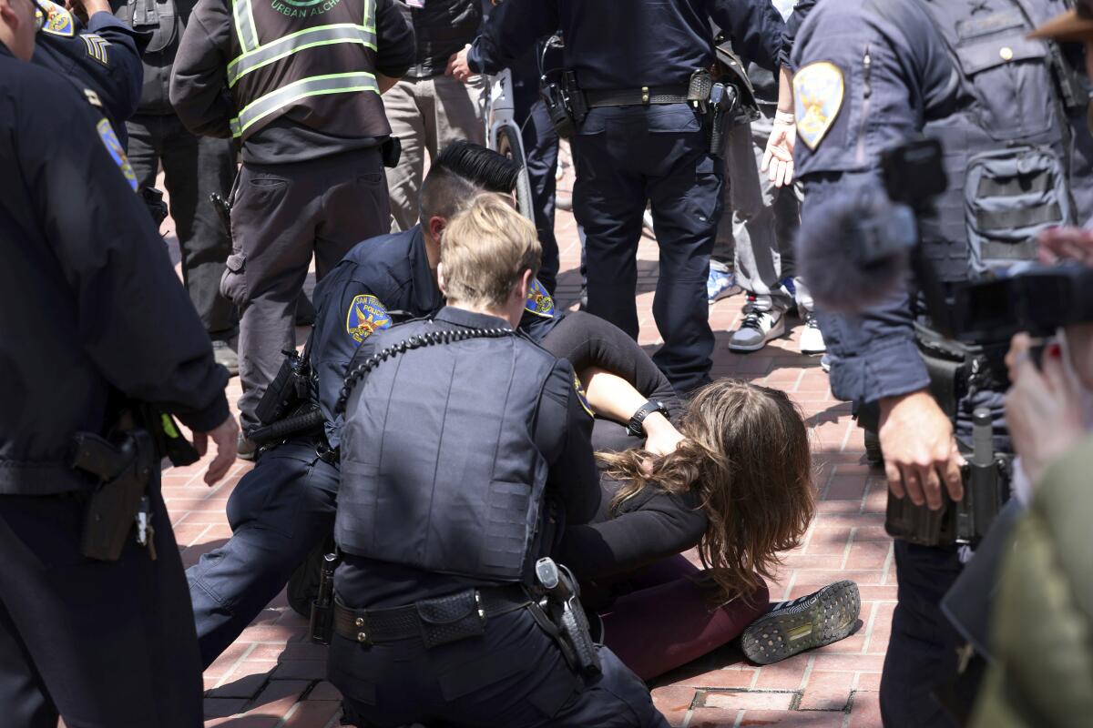 Police detain a protester after they allegedly threw a brick at Mayor London Breed outside UN Plaza in San Francisco