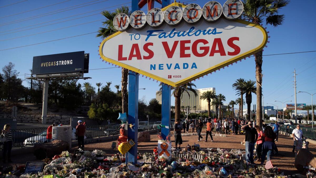 Flowers, candles and other items surround the famous Las Vegas sign at a makeshift memorial for victims of a mass shooting in Las Vegas. Hotel and casino operators say the impact to the meeting industry in the city has been minimal.