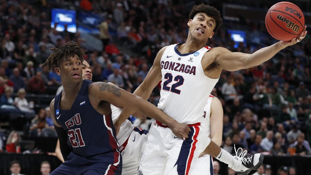 Fairleigh Dickinson forward Elyjah Williams (21) and Gonzaga forward Jeremy Jones (22) go for a rebound during the second half of a first-round game in the NCAA tournament on Thursday in Salt Lake City.