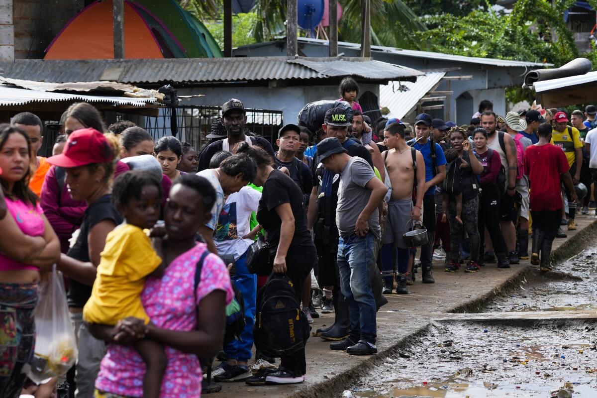 Migrantes hacen fila para identificarse ante funcionarios de la autoridad migratoria panameña.