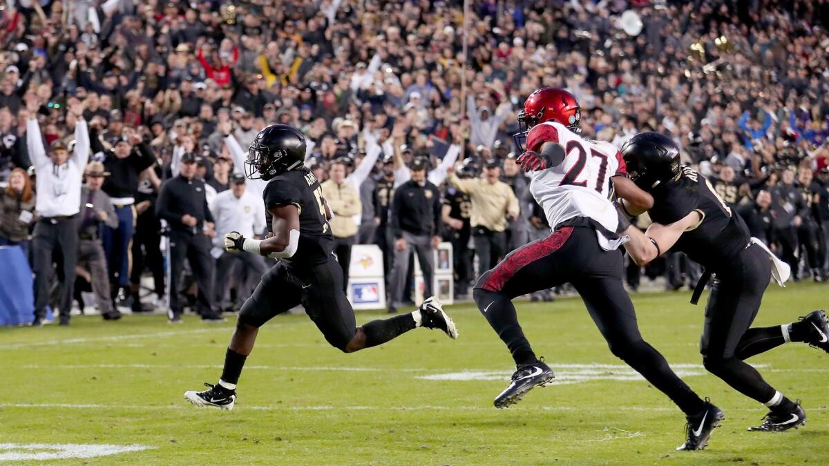 Kell Walker of the Army Black Knights carries the ball to score a two-point conversion against Kyree Woods of the San Diego State Aztecs in the fourth quarter of the Armed Forces Bowl.
