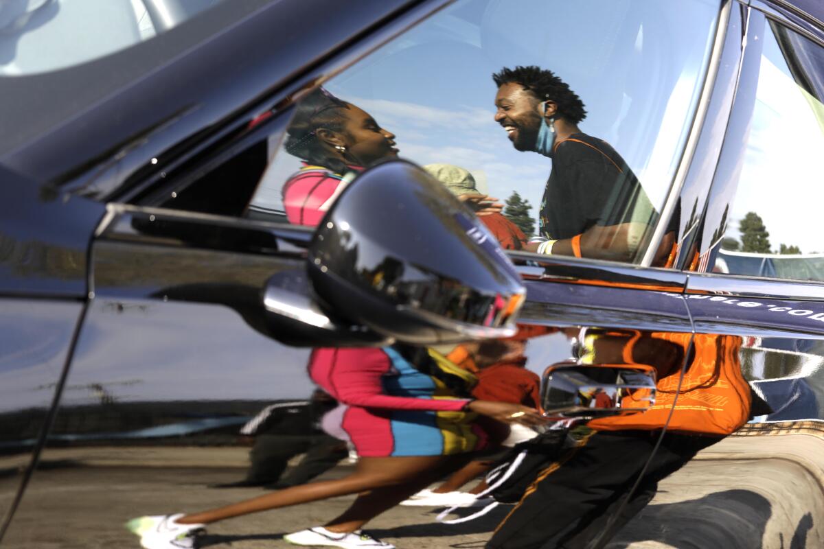 Latasha and Dave Giles II are reflected in a vehicle in Leimert Park.