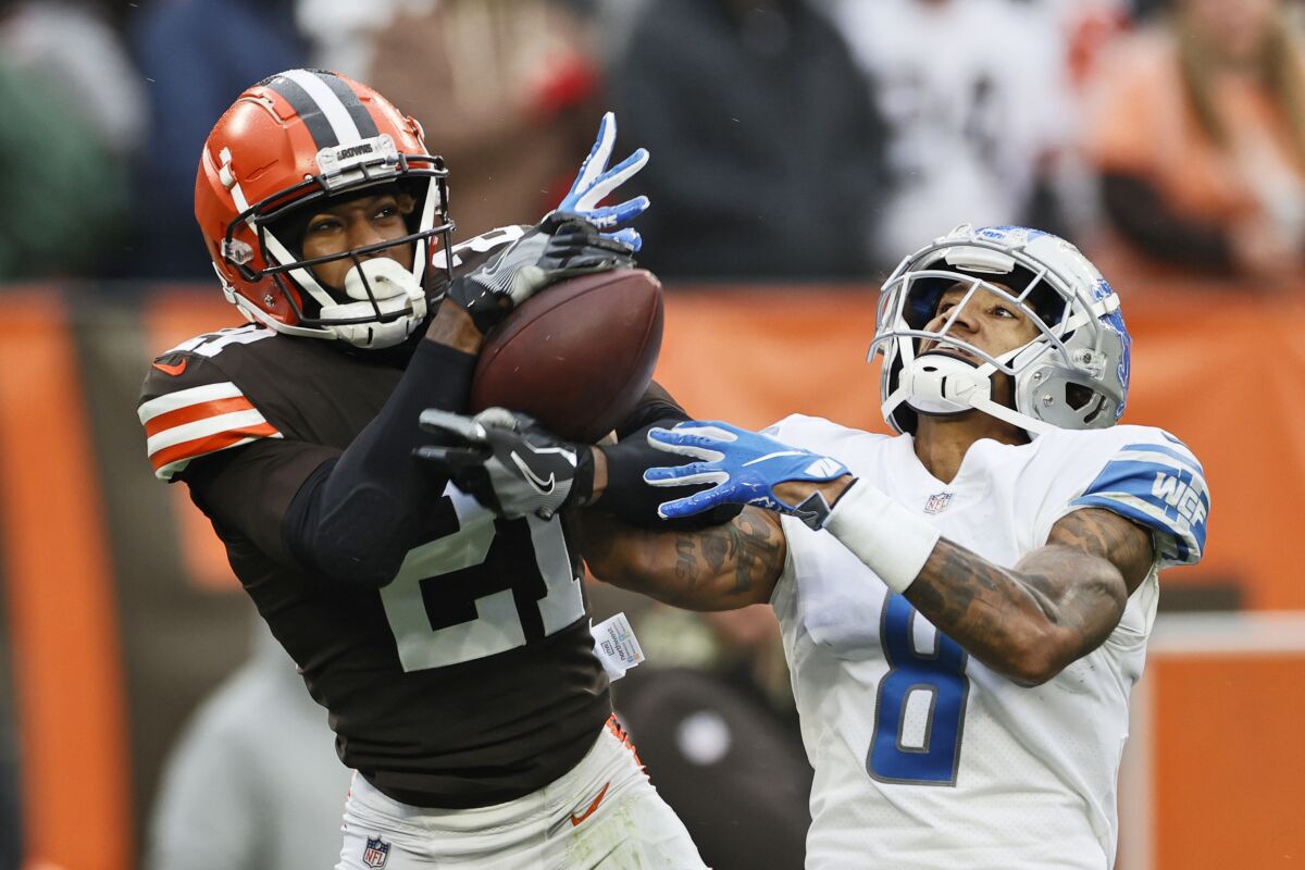 FILE - Cleveland Browns cornerback Denzel Ward (21) intercepts a pass intended for Detroit Lions wide receiver Josh Reynolds (8) during the second half of an NFL football game, Sunday, Nov. 21, 2021, in Cleveland. Cleveland Browns Pro Bowl cornerback Denzel Ward has agreed to a five-year, $100.5 million contract extension with the team, a person familiar with the negotiations told The Associated Press on Monday, April 18, 2022. (AP Photo/Ron Schwane, File)