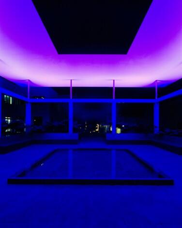 A blue-lighted room under a purple glowing ceiling