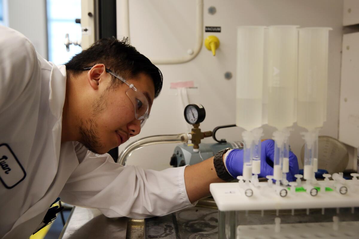 Twan Nguyen checks a machine that is testing surface water for contaminants at the Orange County Water District in 2019.