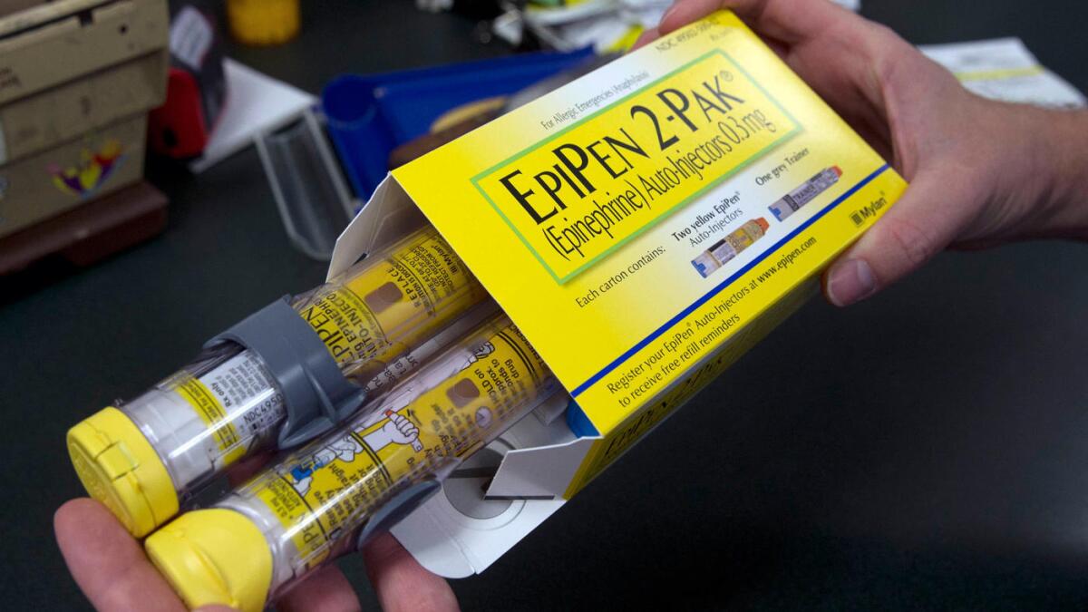 A pharmacist in Sacramento holds a package of EpiPens.