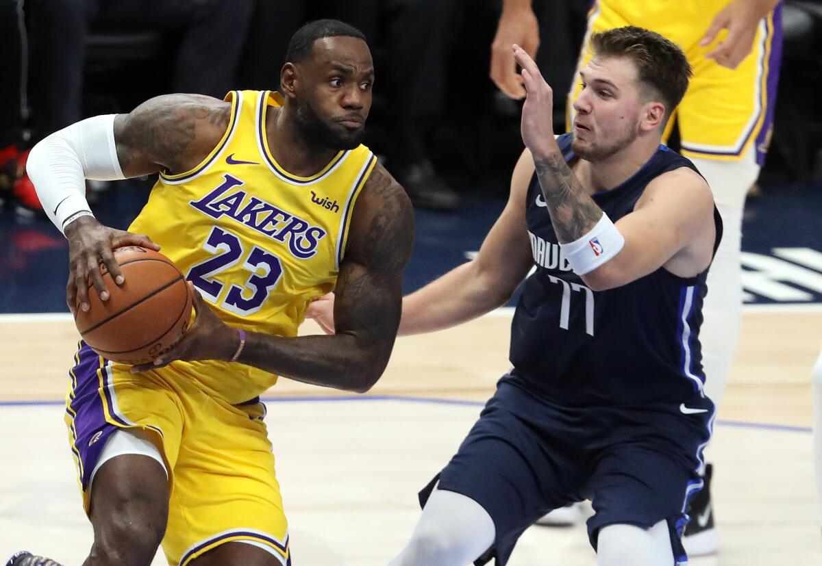 Lakers forward LeBron James drives against Mavericks forward Luka Doncic Nov. 1 in Dallas.