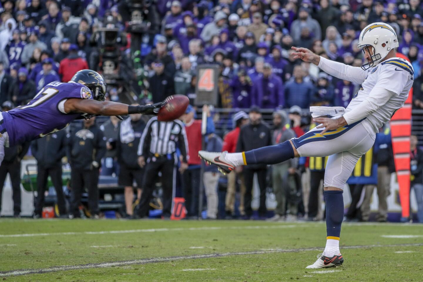 Ravens running back Javorious Allen partially blocks a punt by the Chargers' Donnie Jones during the third quarter.