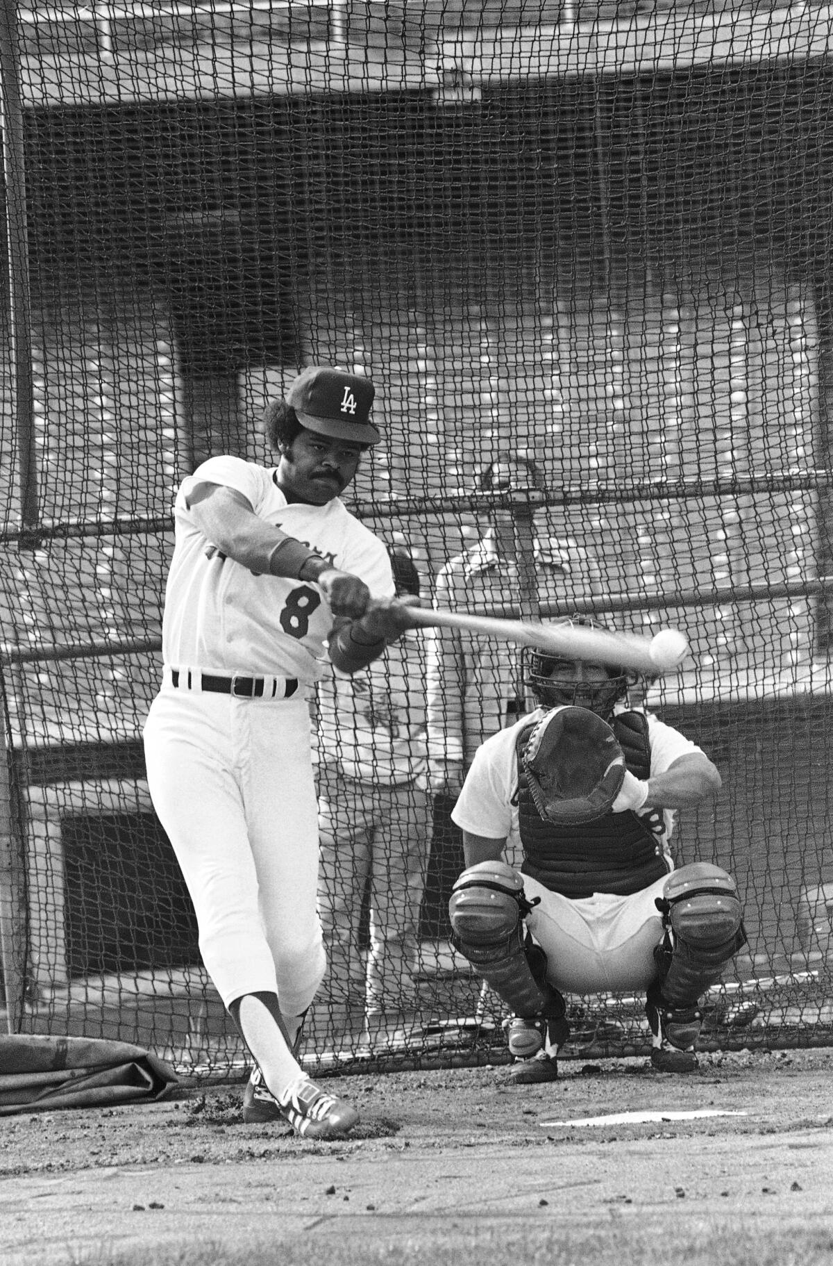 Dodgers outfielder Reggie Smith socks one away from bullpen catcher Mark Cresse during the team’s opening workout in 1978.