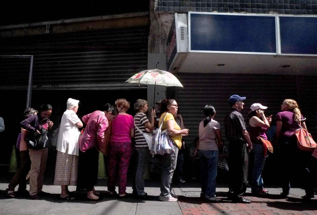 People line up to buy basic items outside a supermarket this week in Caracas. Once-booming Venezuela now suffers from shortages of food, medicine and basic goods.