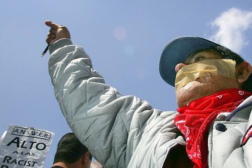 A man wears tape across his mouth to decry pending federal legislation aimed at reducing illegal immigration.