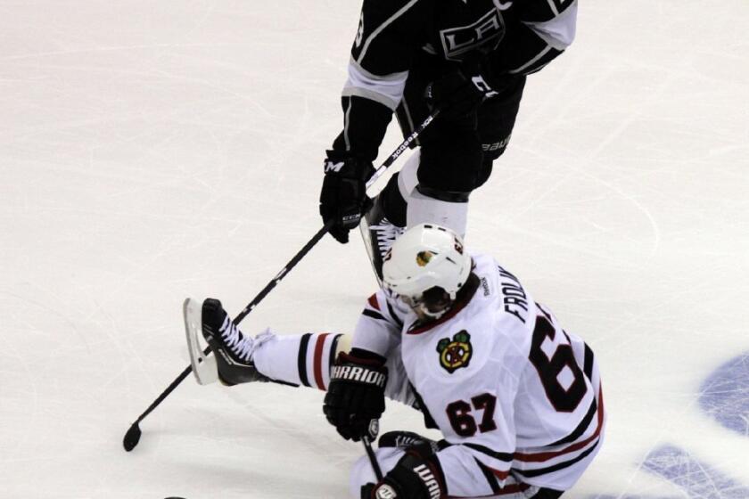 Chicago Blackhawks center Michael Frolik and Kings right wing Dustin Brown battle for the puck at Staples Center.