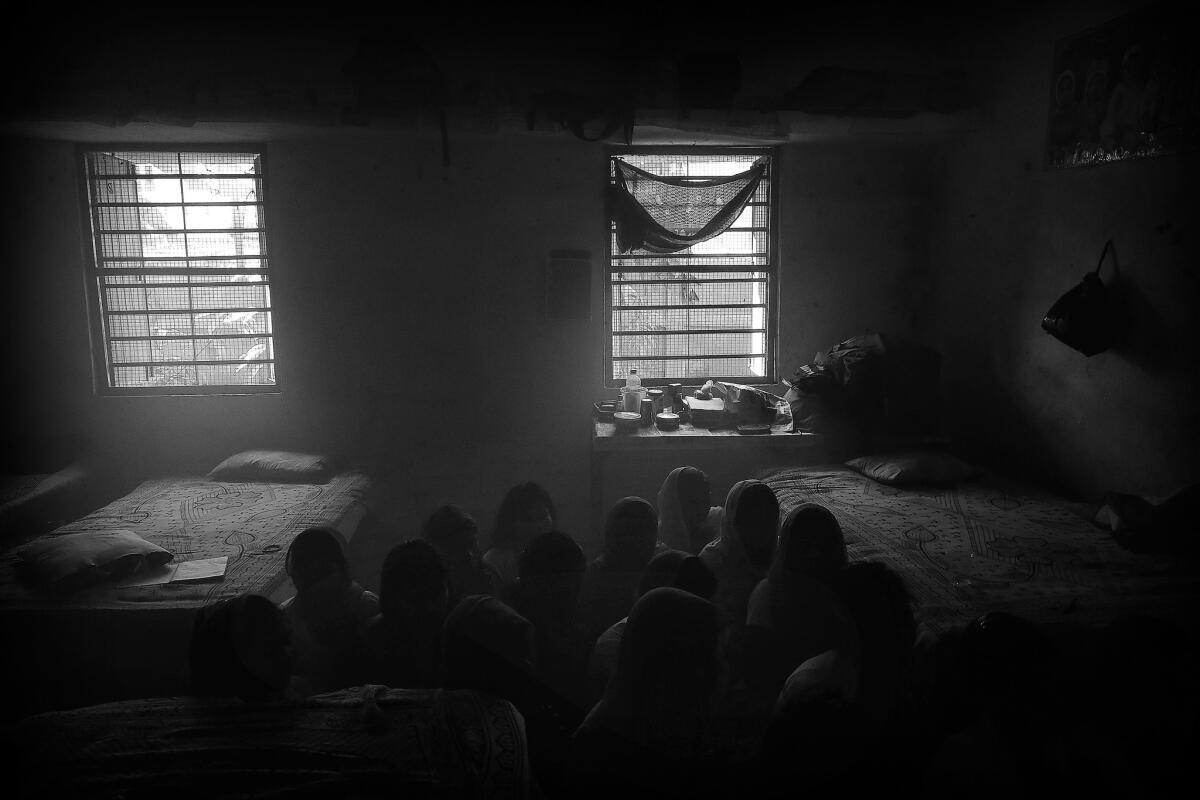 The girls pray together inside their communal bedroom that sleeps 20 during the five holy days of Durga Puja.