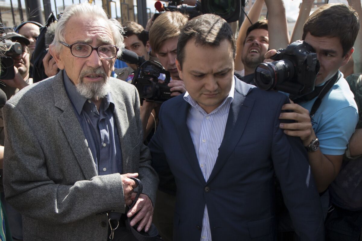 Boris Khodorkovsky, left, arrives with his lawyer Thursday for questioning in a homicide in which Russian authorities claim his exiled son and Kremlin critic, Mikhail Khodorkovsky, is a suspect.