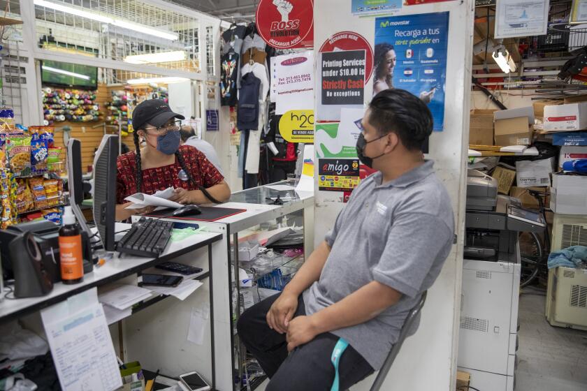 Los Angeles, Calif. -- Saturday, June 12, 2021: CIELO worker Aurora Pedro, left, talks about Covid vaccines with Francisco Hernandez, right, a worker in the Selecto Plaza Mall in Los Angeles, Calif., on June 12, 2021. (Brian van der Brug / Los Angeles Times)