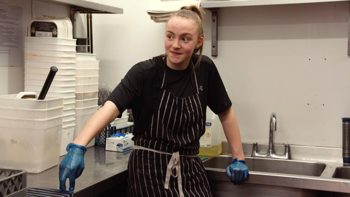 Lili Jones, Wrexham women's soccer player, washes dishes at a restaurant in her day job between matches.