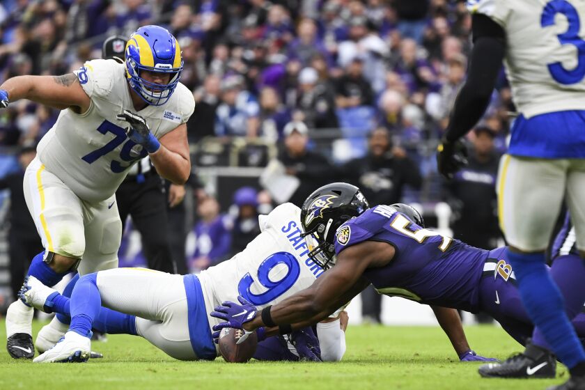 Los Angeles Rams quarterback Matthew Stafford (9) has the ball striped away from him by Baltimore Ravens outside linebacker Tyus Bowser and recovered by outside linebacker Justin Houston during the second half of an NFL football game, Sunday, Jan. 2, 2022, in Baltimore. (AP Photo/Terrance Williams)