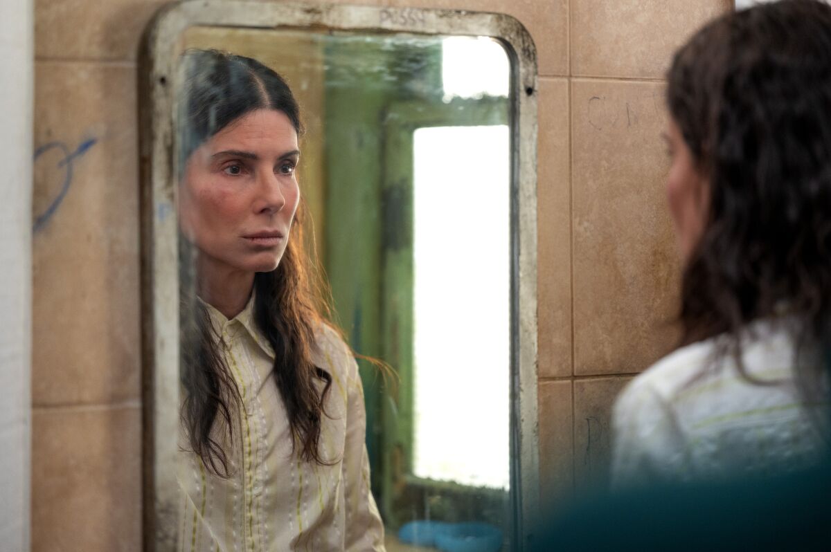 A woman looks at her reflection in a mirror.