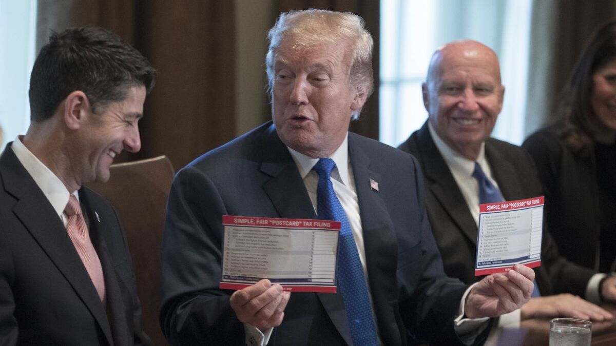 President Trump holds up samples of tax filing "postcards" with House Speaker Paul Ryan, left, and Rep. Kevin Brady, chairman of the House Ways and Means Committee, during a Nov. 2 White House meeting.
