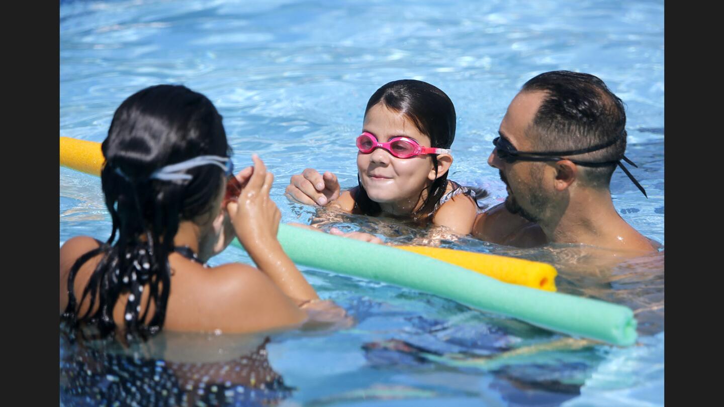 Roxana Rangel, left, her daughter Mia, center, and her husband Gary Rangel take a dip on a warm day at Pacific Park Pool, in Glendale on Saturday Sept. 9, 2017.