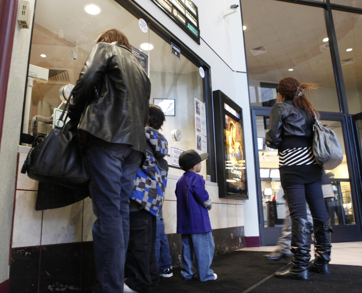 Moviegoers buy tickets at a theater in Denver.