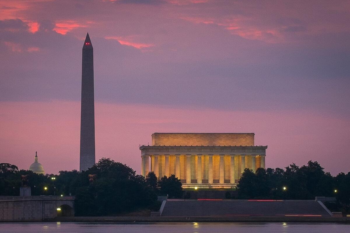 FILE - This June 21, 2014 shows sunrise over, from left, the Capitol Dome, Washington Monument and Lincoln Memorial in Washington.